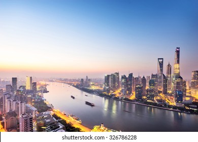 skyscrapers of the city in China surrounded by a river at dusk - Shutterstock ID 326786228