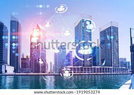 Skyscrapers of Dubai business downtown. International hub of trading and financial services. Social network icons hologram, concept of people connection. Double exposure. Dubai Canal waterfront.