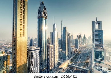 Skyscrapers and highways of a big modern city at sunset. Aerial view on downtown Dubai, United Arab Emirates.