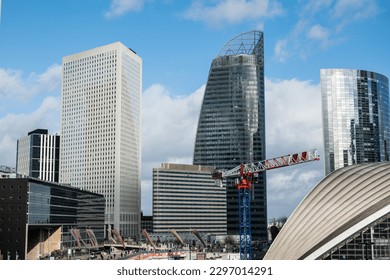 Skyscrapers of La Defense modern business and financial district in Paris with highrise buildings and convention center. Crane and building construction. Blue cloudy sky