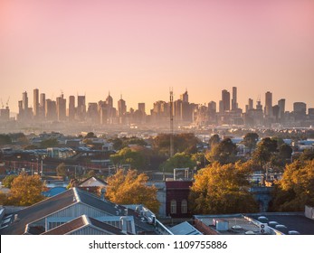 Skyscrapers in Melbourne's CBD in morning mist. Elevated view overlooking residential houses in western suburbs and modern buildings in city. Footscray, VIC Australia.