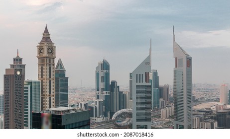 Skyscrapers On Sheikh Zayed Road And DIFC Day To Night Transition Timelapse In Dubai, UAE. Towers In Financial Centre Aerial View From Above. Cloudy Sky After Sunset