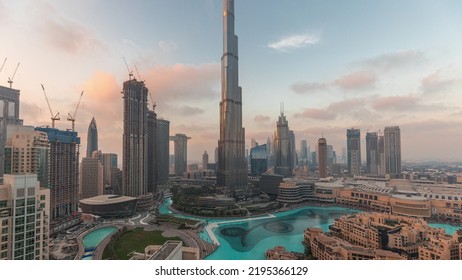 Skyscrapers Rising Above Dubai Downtown Day To Night Transition Timelapse, Mall And Fountain Surrounded By Modern Buildings Aerial Top Panoramic View With Cloudy Colorful Sky