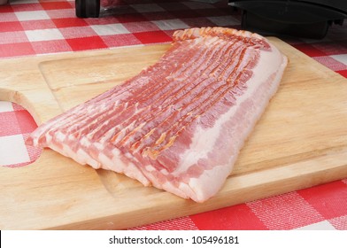 A Slab Of Raw Bacon Near The Grille