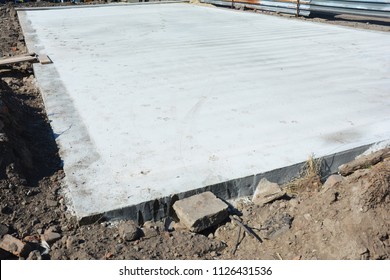 Slab-on-grade Foundation On House Construction Site. Monolithic Slabs Are Foundation Systems Constructed As One Single Concrete Pour That Consists Of A Concrete Slab. 