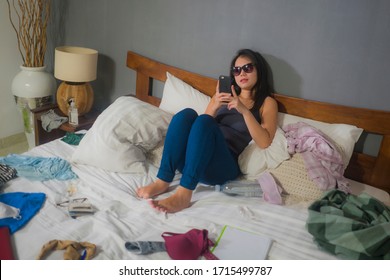 Slackness And Disorganized During Covid-19 Home Lockdown - Young Disorderly And Chaotic Asian Chinese Woman On Bed Using Internet Mobile Phone On Grimy Messy Bedroom In Social Media Addiction