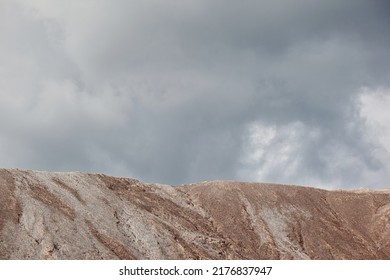 Slag From Waste Rocks From Clay And Sand. Industrial Mountain Against The Backdrop Of Nature And Blue Sky