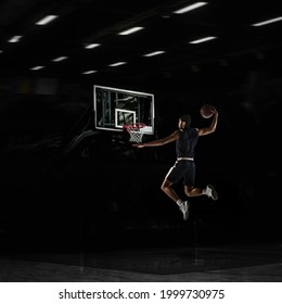 Slam Dunk. Young African Sportsman, Basketball Player Training In Gym, Idoors Isolated On Dark Background With Spotlights. Concept Of Energy, Power, Motion. Copyspace For Ad, Design. Collage, Artwork