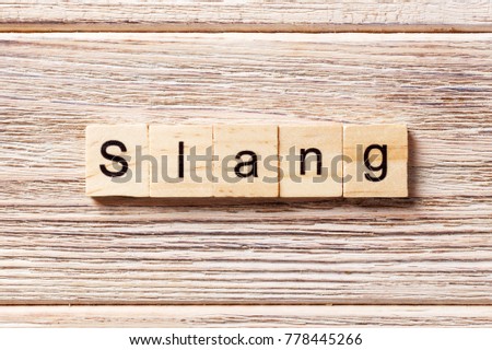 slang word written on wood block. slang text on table, concept.