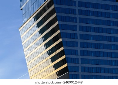 Slanted surface of a modern glass skyscraper exterior at sunset