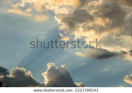 Slanting sun rays from setting sun spreading out amongst dramatic, angry storm cloud formation in the sky over Phoenix, Arizona, USA. Copy space.