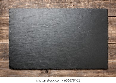 Slate blackboard on wooden background