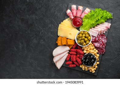 Slate board with slicing of different sausages and cheese. Charcuterie board. Meat delicacies. Top view with copy space.