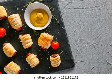 Slate Plate With Tasty Sausage Rolls And Sauce On Table, Top View