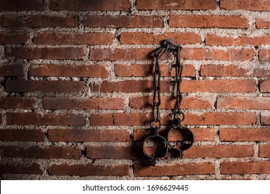 Slavery And Bondage Strong Steel Old Shackles Isolated On Bricks Background