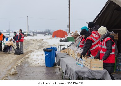 SLAVONSKI BROD, CROATIA - JANUARY 7, 2016 : Red Cross Volunteers At Stand With Food And Water For Immigrants And Refugees From Middle East And North Africa In Transit Through Croatia.