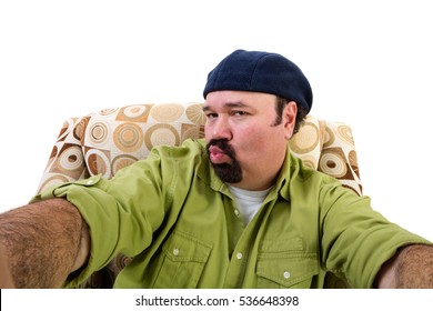 Sleazy Overweight Man In Armchair Blowing Kiss And Taking Selfie, White Background