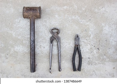 Sledge hammer, tongs, pliers, on concrete. Blacksmith tools, top view. - Powered by Shutterstock