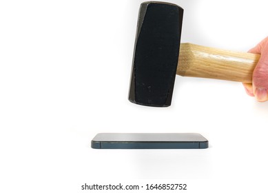 A Sledgehammer Is About To Smash A Smart Phone. The Handheld Sledgehammer Is Directly Above The Smart Phone Which Is Lying Horizontally.