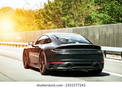 Sleek Black German Roadster. Brand New Luxury Carrera Sports Car on the Highway. Rear view of the 911 GTS sports car. - Shutterstock ID 2331577243