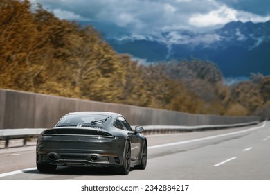 Sleek Black German Roadster. Brand New Luxury Carrera Sports Car on the Highway. Rear view of the 911 GTS sports car. - Shutterstock ID 2342884217