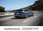 A sleek blue station wagon speeds along a coastal highway, with lush greenery and ocean views in the background, reflecting the spirit of summer travel