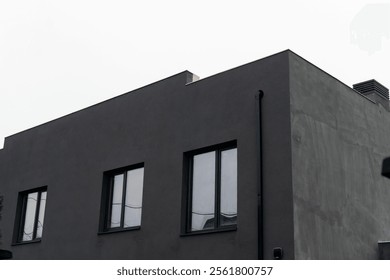 Sleek gray structure with multiple large windows under an overcast sky in an urban setting