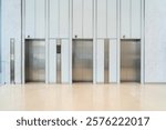 Sleek Three modern elevator with stainless steel doors, white walls, and glossy beige flooring, The professional interior design setting in modern building or office building
