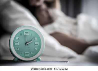 Sleep Changes And Disorders Or Insomnia In Elderly Concept.Alarm Clock Time At 2 A.m. Morning With Blurry Women Lay Down Awake.