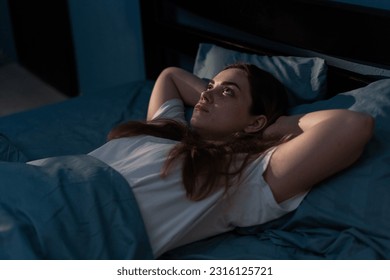 Sleep disorder, insomnia. Young woman lying on the bed awake at late night. Can not sleep - Powered by Shutterstock