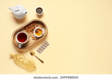 Sleep mask, pills and tea set with wooden tray on beige background - Powered by Shutterstock