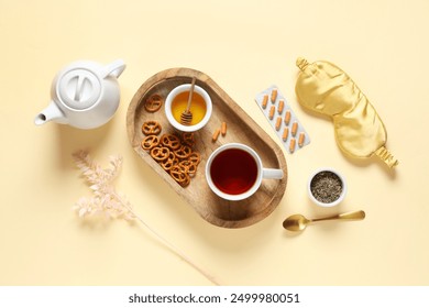 Sleep mask, pills and tea set with wooden tray on beige background - Powered by Shutterstock