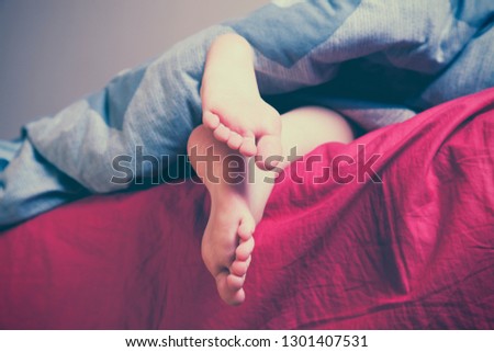 Sleep and relax concept. Close up feet of a girl lying in bed.  