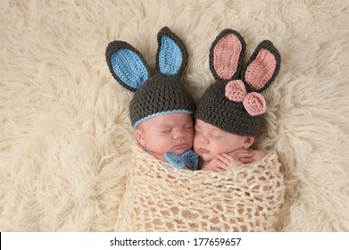 Sleeping 2 Month Old Newborn Baby Twins Wearing Bunny Costumes. They Are Swaddled Together In A Hugging Position.