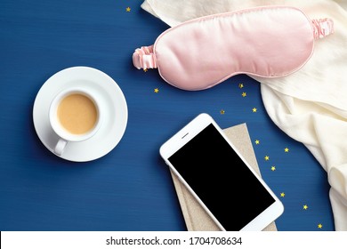 Sleeping App For Insomnia, Fall Asleep Concept. Flat Lay Home Desk With Cup Of Coffee, Sleep Mask, Blanket And Smartphone With Blank Screen Mockup.