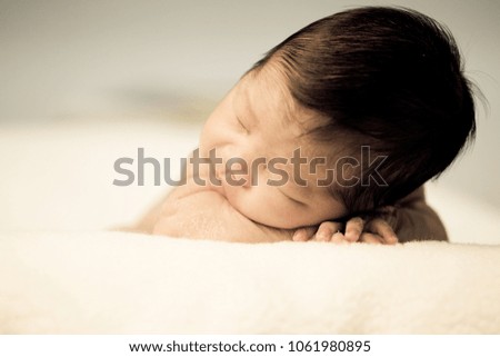 Similar – Newborn baby girl sleeping lying on blanket on bed