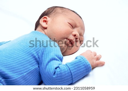 Similar – Newborn baby girl sleeping on blue sheets at home