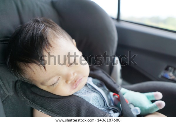 Sleeping baby boy in a car\
seat