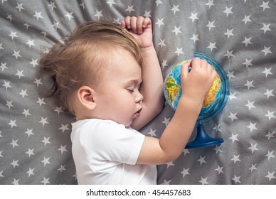 Sleeping Baby Holding A Globe In His Hands And Dreaming About Future Travels.