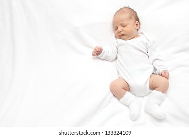 Sleeping Baby On Back On White Bed