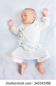 Sleeping Baby On Back On White Bed