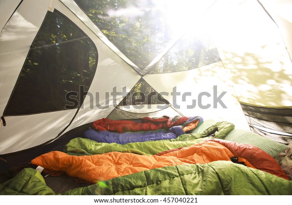 Sleeping\
bags lined up in a tent full of sleeping\
bags