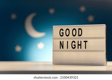 sleeping and bedtime concept - close up of customizable light box with good night words over moon and night stars on blue background