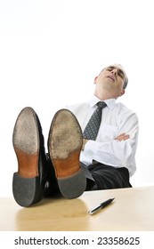 Sleeping businessman with feet up on his desk