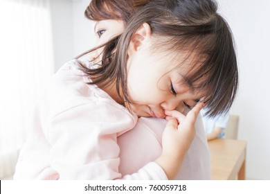 Sleeping child carried by mother - Shutterstock ID 760059718