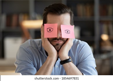Sleeping clerk hides eyes with sticky notes, open eyes drawn on adhesive papers, he wants to sleep at workplace due lack of energy, chronic fatigue, not inspired, no motivation office employee concept