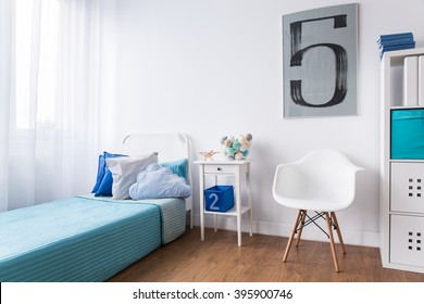 Sleeping cozy corner with single blue bed in modern room designed for boy