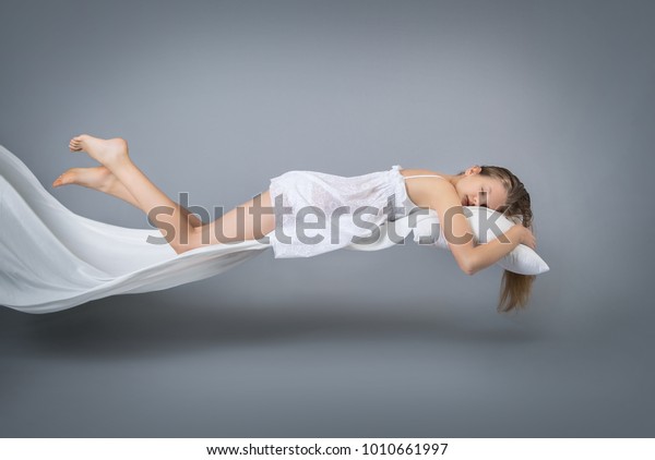 寝てる女の子 夢の中で飛ぶ グレイの背景に水平の写真 の写真素材 今すぐ編集
