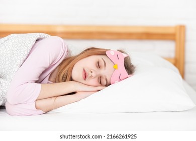 Sleeping Girl Wearing Funny  Eyemask Lying On A Pillow In Bedroom. Cute Teen Girl With Closed Eyes Relaxing At Home. Healthy Sleep Concept. Copy Space. Selective Focus.