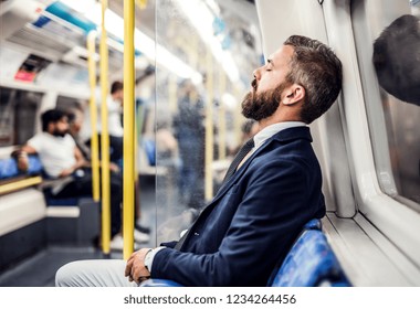 Sleeping hipster businessman inside the subway in the city, travelling to work. - Powered by Shutterstock